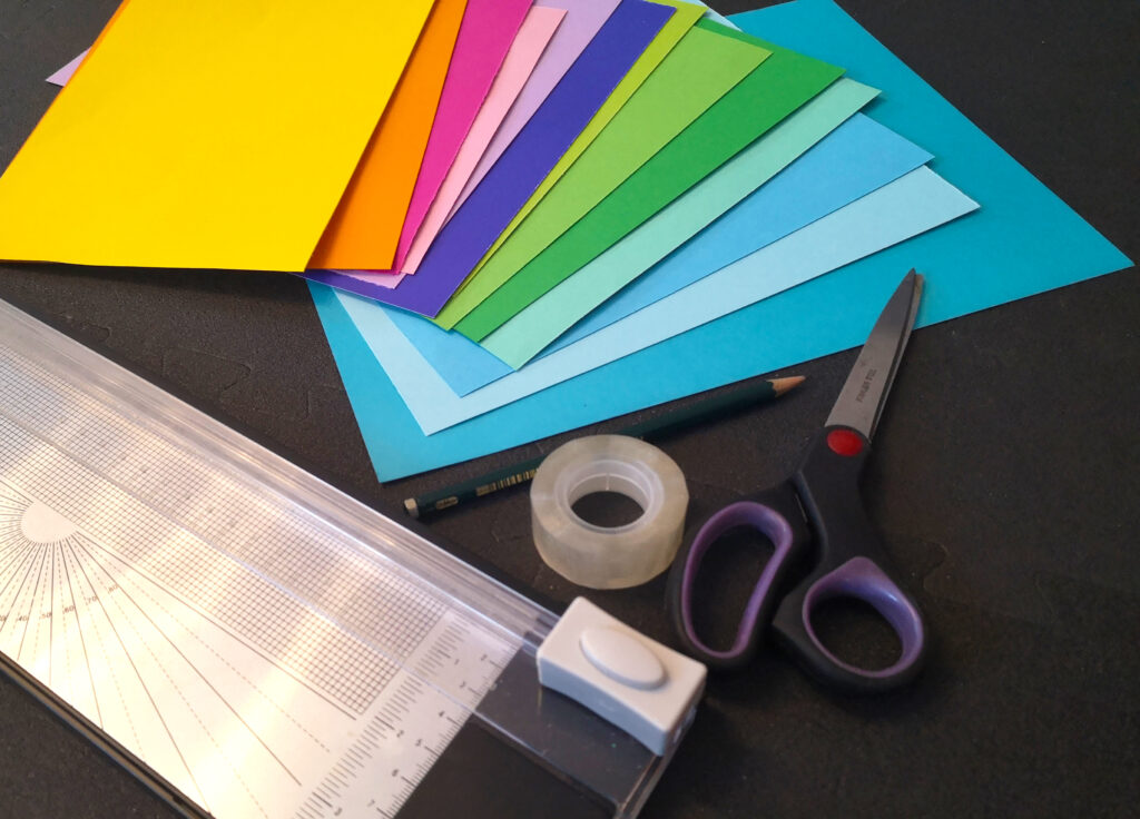 Übersicht Bastelmaterial buntes Tonpapier Schere Klebeband Cutter Bleistift