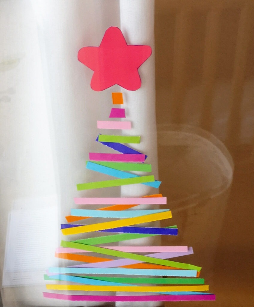 Bunter Weihnachtsbaum an einer Fensterscheibe